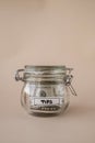 Saving Money In Glass Jar filled with Dollars banknotes. TIPS transcription in front of jar. Managing personal finances Royalty Free Stock Photo