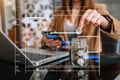 Saving money with hand putting coins in jug glass and calculator to calculate budget concept finance and accounting Royalty Free Stock Photo