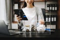 saving money with hand putting coins in jug glass and calculator to calculate budget concept finance and accounting and Gantt Royalty Free Stock Photo