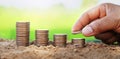 saving money hand putting coins on stack on soil with sunshine. concept finance and accounting Royalty Free Stock Photo