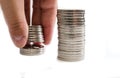 Saving money hand putting coins on stack on table .Close-up. White background.