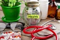 Saving money for health care insurance - money glass, stethoscope, pills and bottles Royalty Free Stock Photo