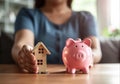 Saving money for house and real estate. Woman hand protecting on stack coins and house model on table. AI Generated Royalty Free Stock Photo