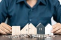 Saving money for house and real estate. Woman hand protecting on stack coins and house model on table Royalty Free Stock Photo