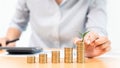 Saving money and investment concept, Business accountant woman stacking coins into increasing columns stack for budget behind desk Royalty Free Stock Photo