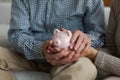 Saving money investment for future. Senior adult mature couple hands holding piggy bank with money coin. Old man woman Royalty Free Stock Photo