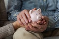 Saving money investment for future. Senior adult mature couple hands holding piggy bank with money coin. Old man woman Royalty Free Stock Photo