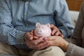 Saving money investment for future. Senior adult mature couple hands holding piggy bank with money coin. Old man woman Royalty Free Stock Photo