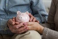 Saving money investment for future. Senior adult mature couple hands holding piggy bank with money coin. Old man woman Royalty Free Stock Photo