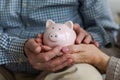 Saving money investment for future. Senior adult mature couple hands holding piggy bank with money coin. Old man woman Royalty Free Stock Photo