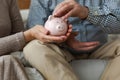 Saving money investment for future. Senior adult mature couple hands putting money coin in piggy bank. Old man woman Royalty Free Stock Photo