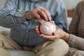 Saving money investment for future. Senior adult mature couple hands putting money coin in piggy bank. Old man woman Royalty Free Stock Photo