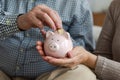 Saving money investment for future. Senior adult mature couple hands putting money coin in piggy bank. Old man woman Royalty Free Stock Photo