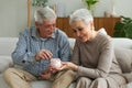 Saving money investment for future. Senior adult mature couple holding piggy bank putting money coin. Old man woman Royalty Free Stock Photo