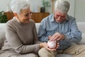 Saving money investment for future. Senior adult mature couple holding piggy bank putting money coin. Old man woman Royalty Free Stock Photo