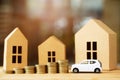 Saving money, Little toy car, money coins stacked on each other in different positions, house in paper model on the wooden table. Royalty Free Stock Photo