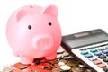 Saving money, piggy bank on coin and calculator Royalty Free Stock Photo