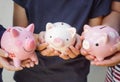 Three kids holding piggy banks