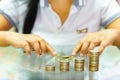 Saving money, woman stacking coins into increasing columns Royalty Free Stock Photo