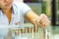 Saving money concept, woman stacking coins increasing.