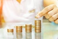 Saving money, woman stacking coins into increasing columns Royalty Free Stock Photo