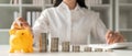 Saving money. young woman asian putting a coin into a money piggy bank Royalty Free Stock Photo