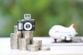 Saving planning for Travel budget of holiday concept, Model camera on stack of coins money and airplane on passport with natural Royalty Free Stock Photo