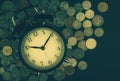 Saving time, Alarm clock with coins isolated on black background. with vintage filter.