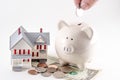 Saving to build / buy a home / house. Piggy bank with coin being Royalty Free Stock Photo