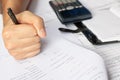 Savings, finances, economy and home concept - close up of man with calculator counting making notes in the crisis at home. Royalty Free Stock Photo