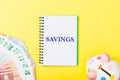 Savings headline in notebook on yellow background