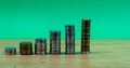 Savings, increasing columns of gold and silver coins isolated on green background Royalty Free Stock Photo