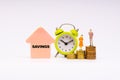 SAVINGS inscription written, alarm clock, coins and businessman miniature