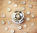 . Savings, investment and a jar full of coins on a wooden table for future financial growth or insurance. Overhead view Royalty Free Stock Photo