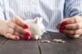 Savings, money, annuity insurance, retirement and people concept - close up of senior woman hand putting coin into piggy bank Royalty Free Stock Photo