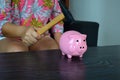 Woman is going to break a piggy bank with a hammer. Royalty Free Stock Photo