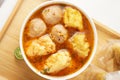 Savor a bowl of Cuankie meatball soup with round meatballs, tofu, fried wontons, and savory spicy broth