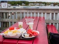 Lobster meal with french fries at a red table with the beautiful New England boats behind Royalty Free Stock Photo
