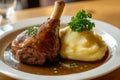 Delicious eisbahn pork knuckle served with creamy mashed potatoes and flavorful stewed cabbage on a rustic wooden table Royalty Free Stock Photo