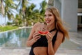 Savoring Paradise: Exquisite Brunette Model Delights in Savory Watermelon Indulgence Amidst Glamorous Vacation Abroad