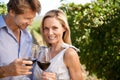 Savoring wine in the vineyard. Portrait of a happy couple enjoying a glass of wine in a vineyard. Royalty Free Stock Photo