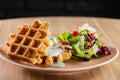 Savory Belgian waffles with cheese sauce and salad