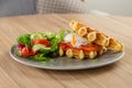 Savory Belgian waffles with egg poached, salmon and salad. eggs