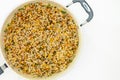 A savory blend of pearled couscous, orzo, baby garbanzo beans, and red quinoa close up on frying pan on white background