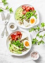 Savory breakfast grain bowl. Balanced buddha bowl with quinoa, egg, avocado, tomato, green pea on light background. Healthy diet Royalty Free Stock Photo