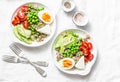 Savory breakfast grain bowl. Balanced buddha bowl with quinoa, egg, avocado, tomato, green pea on light background. Healthy diet