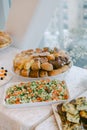 Savory buffet display featuring fresh vegetables, bread rolls, and a vibrant salad at a daytime event Royalty Free Stock Photo