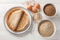 Savory crepes Buckwheat Galettes closeup on a plate with ingredients flour, cereal and eggs closeup on the wooden table.