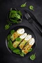 Savory crepes with spinach and feta cheese on black background, top view