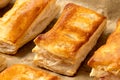Savory filled puff pastries on baking paper. High angle